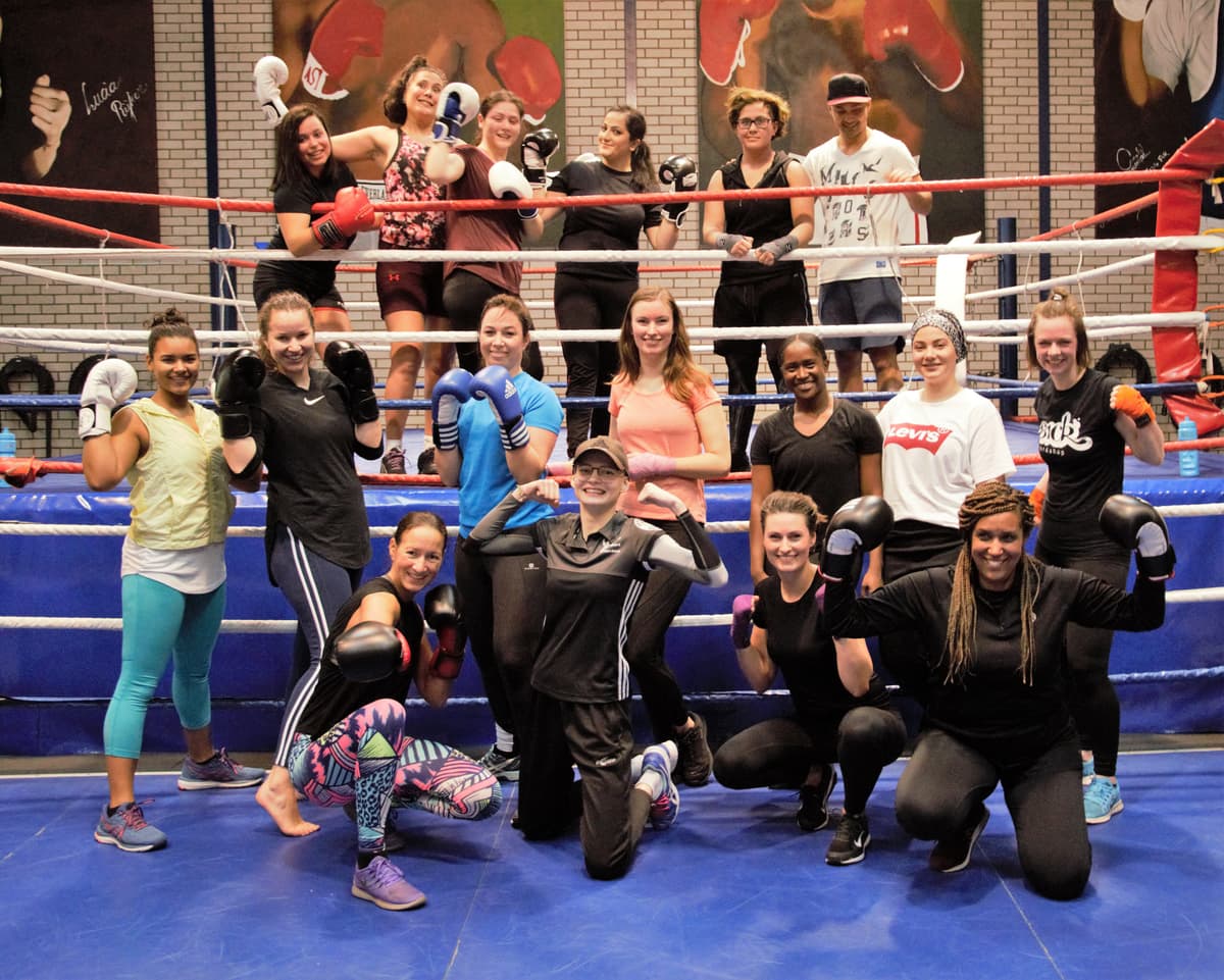Een groep vrouwen met bokshandschoenen in een boksring