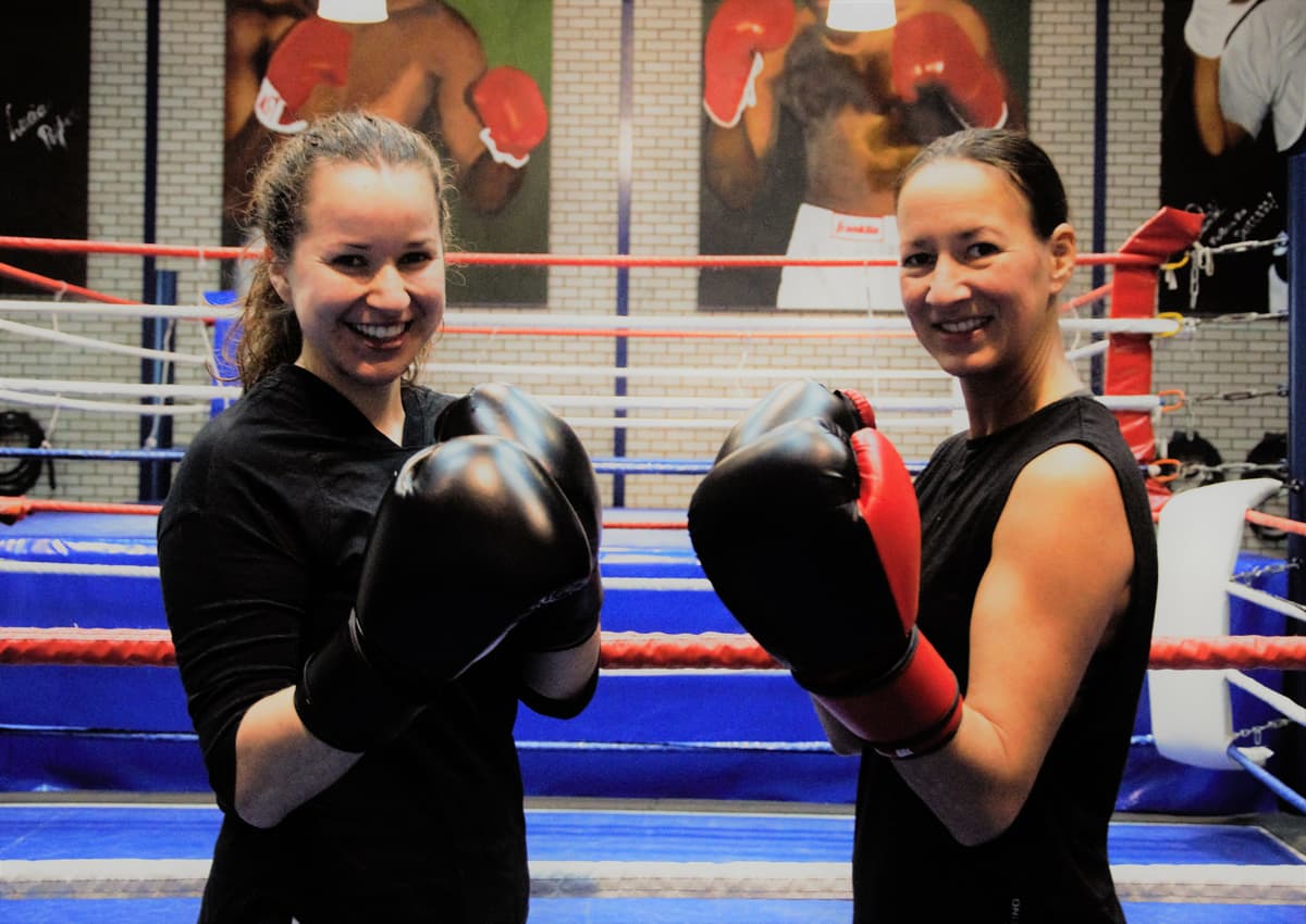 Twee vrouwen met bokshandschoenen in een boksring
